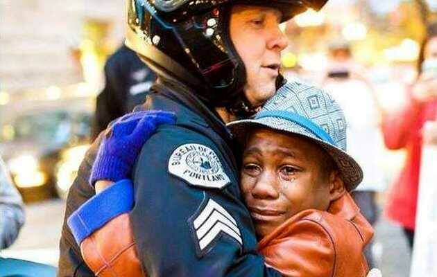 abrazo policia blanco niño negro
