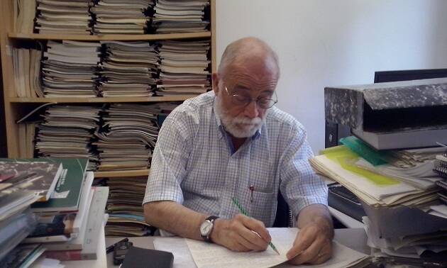 Arcadi Oliveres en su despacho, mientras corrige exámenes de sus alumnos. Foto: Jonatán Soriano,Arcadi Oliveres