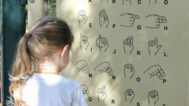 Niña frente a abecedario en lengua de signos. / Flickr, SaraSmo,