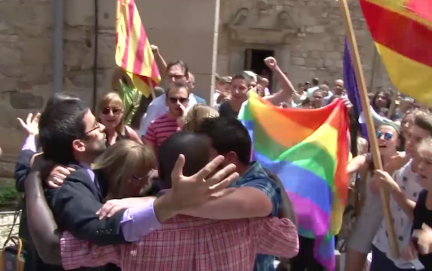 Varios fieles católicos oran juntos ante los gritos de los manifestantes. / TV3,