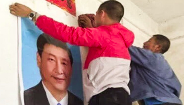 Unos jóvenes colocan el retrato de Xi Jinping, en Yugan. / Lvv2.com, South China Morning Post,