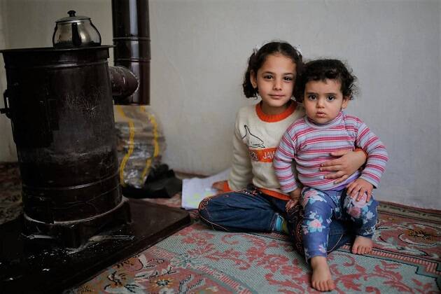 De siete años, Vahide sostiene a su hermana en su casa en Estambul. / © UNHCR, Emrah Gurel,