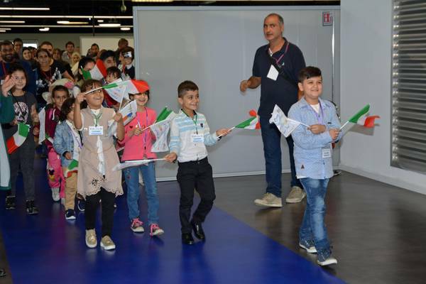 Algunos de los niños, al llegar a Italia, con banderas del país que les acoge. / MediterraneanHope,
