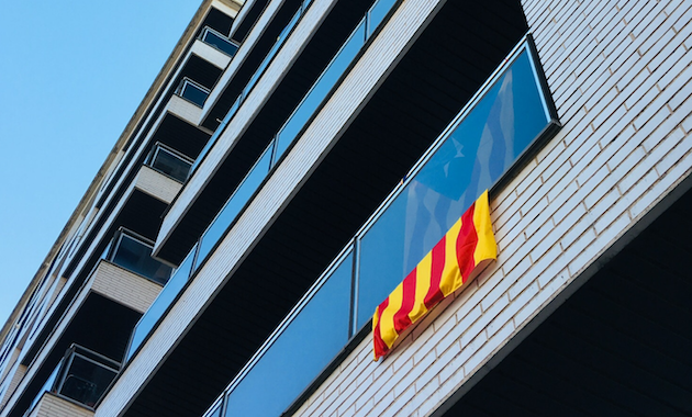 Una bandera independentista asomando por un balcón. / David Pisnoy, Unsplash CC,