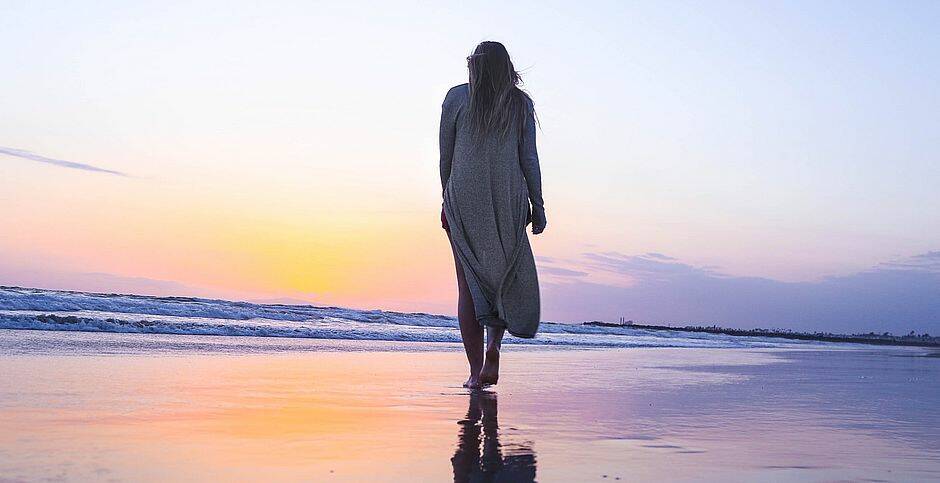 mujer caminando en una playa