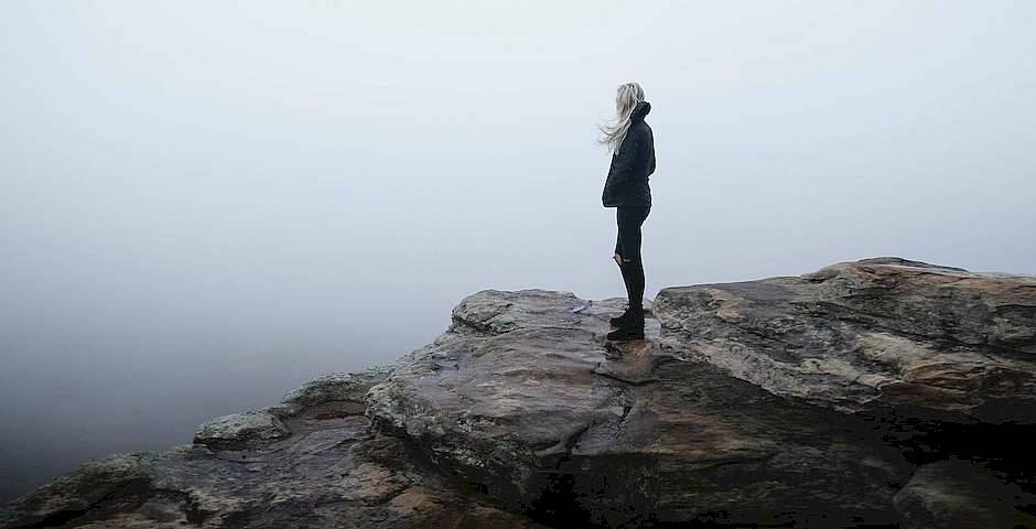 mujer en la cima de una montaña