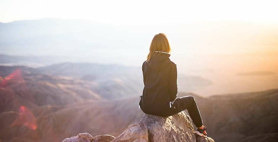 mujer en un pico de montaña